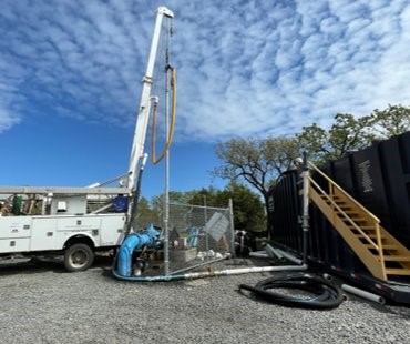 a truck and well drilling site under a blue sky